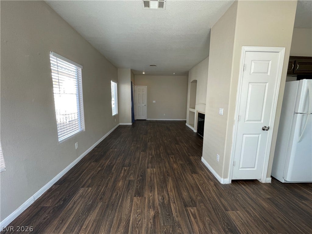 7873 Blue Brook Drive, Las Vegas, NV 89147 Gleaming wood-inspired flooring stretches through this open layout featuring a cozy corner fireplace.