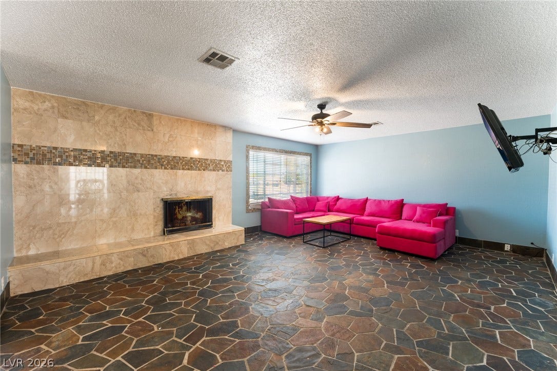 A grand stone fireplace anchors the living space featuring custom flagstone flooring throughout.