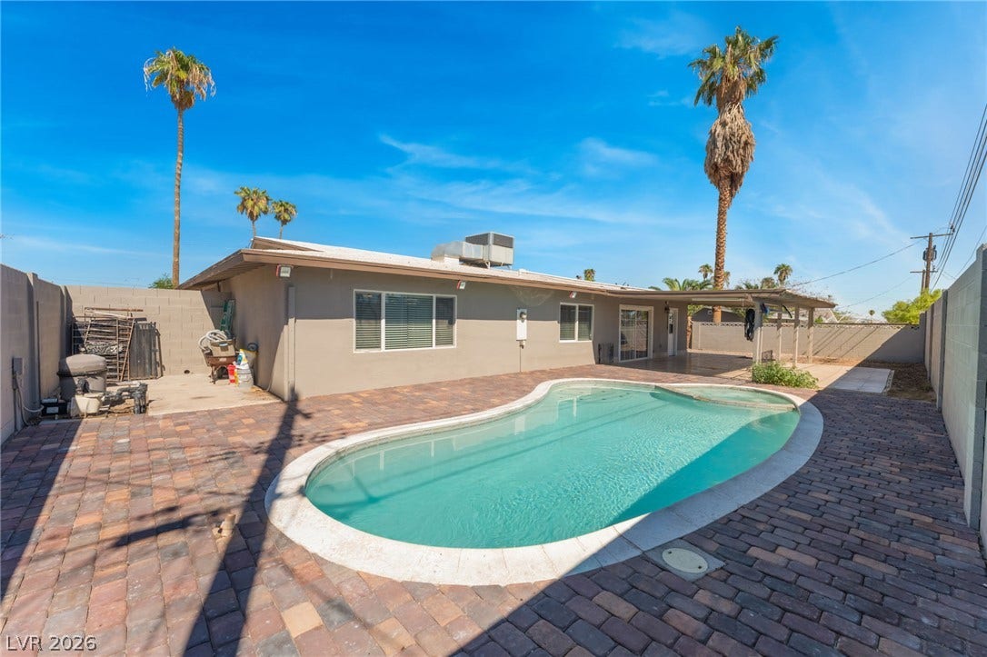 An inviting swimming pool anchor the private backyard surrounded by brick pavers.