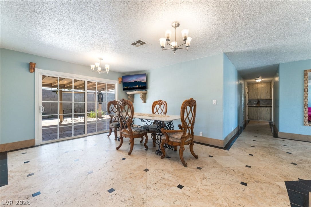Gleaming tile floors with decorative inserts define this airy dining area opening to the patio.
