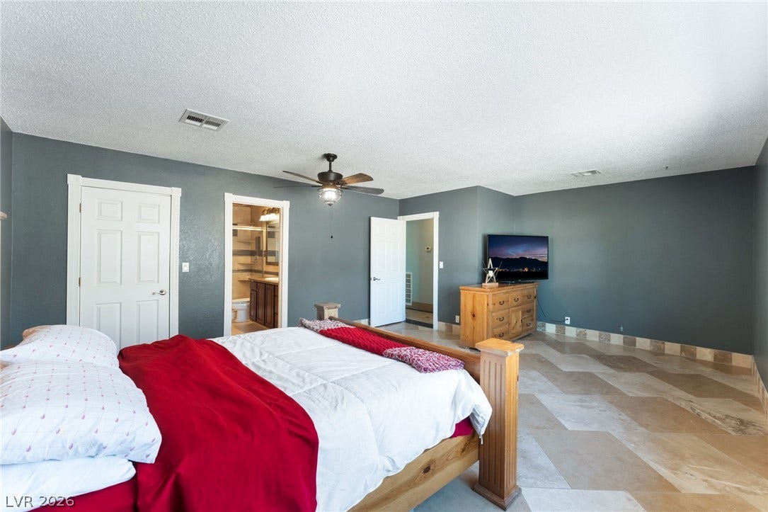 Polished tile flooring sweeps through a generously sized suite with an attached bath.
