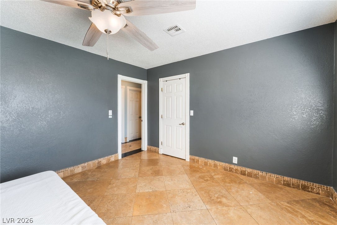 Durable tile flooring and structured baseboards define this functional bedroom space.