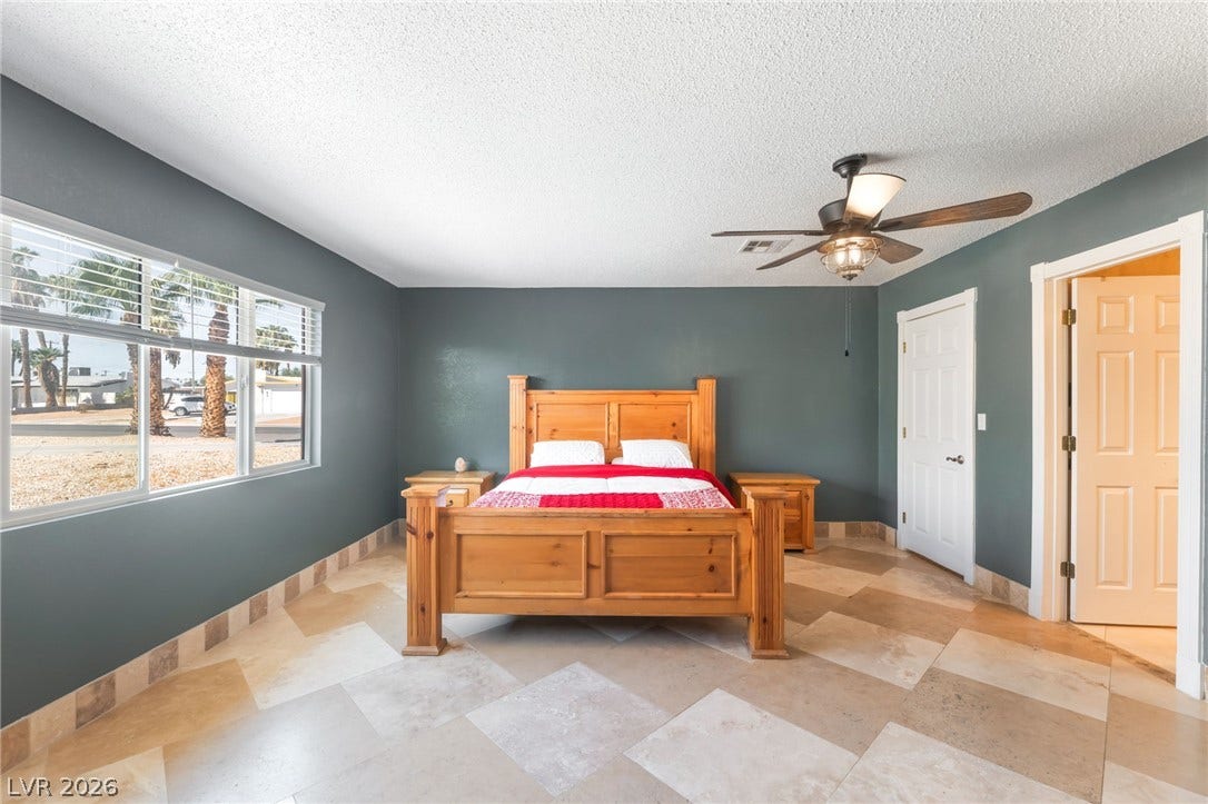 Generous window openings invite natural light across patterned tile flooring in this tranquil bedroom.