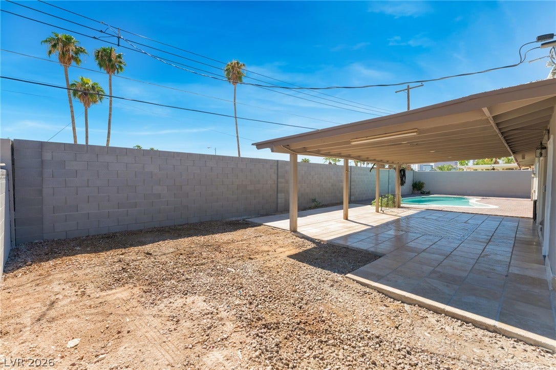 An expansive covered patio overlooks a private yard with a swimming pool.