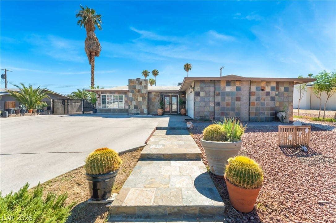 Midcentury architectural lines meet distinctive stone exterior accents and low-maintenance desert landscaping.