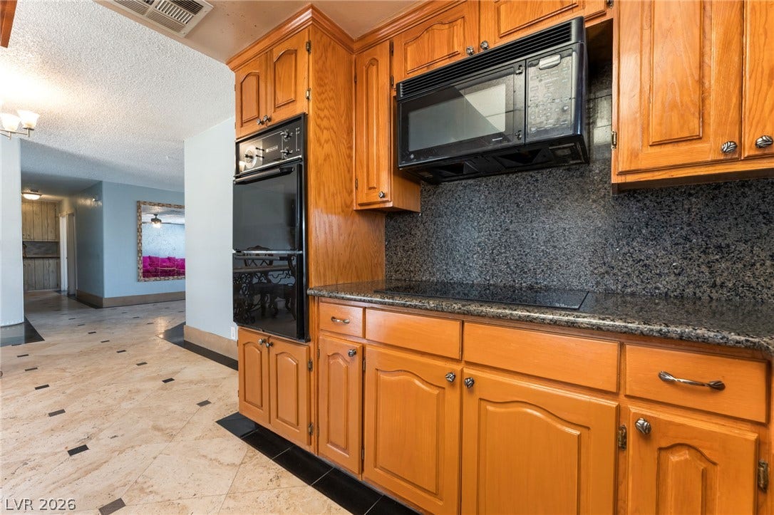 Rich wood cabinetry and polished stone countertops anchor this classic kitchen layout.