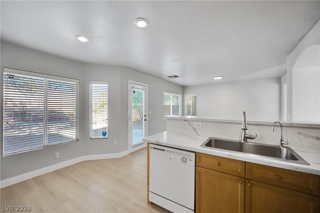 An open breakfast area flows seamlessly from the kitchen, illuminated by recessed lighting.