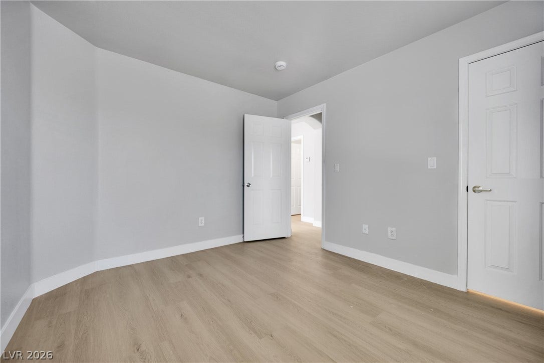Smooth wood floors and crisp trim define this versatile neutral bedroom.