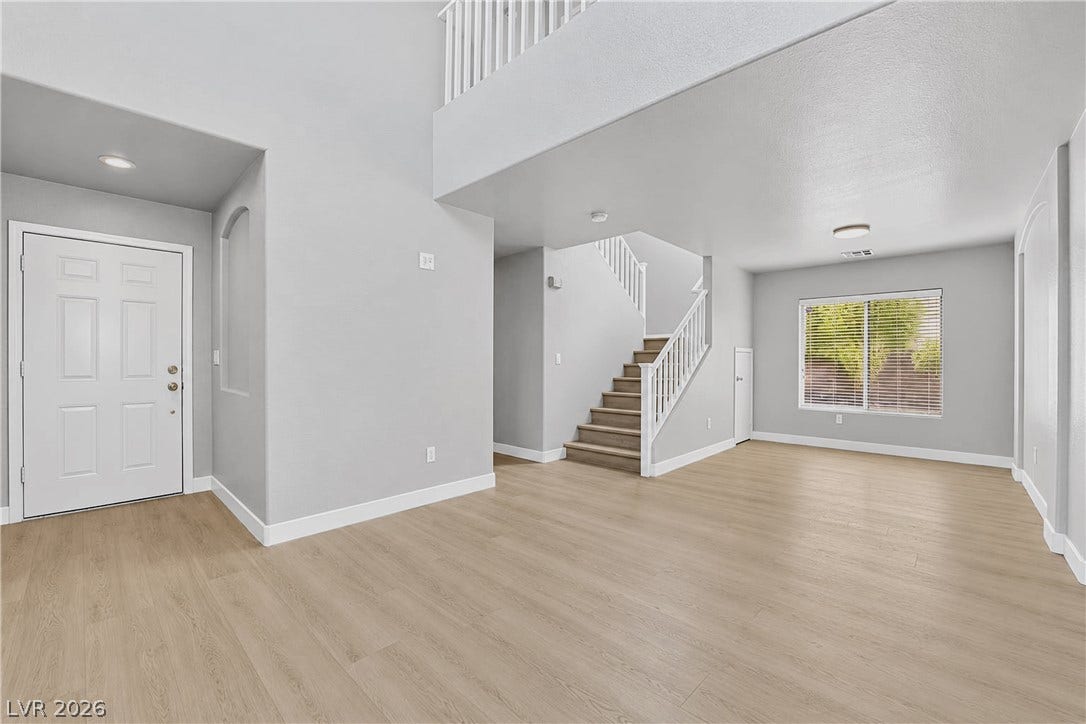 Gleaming hardwood floors and a lofty two-story ceiling welcome visitors inside this airy entryway.