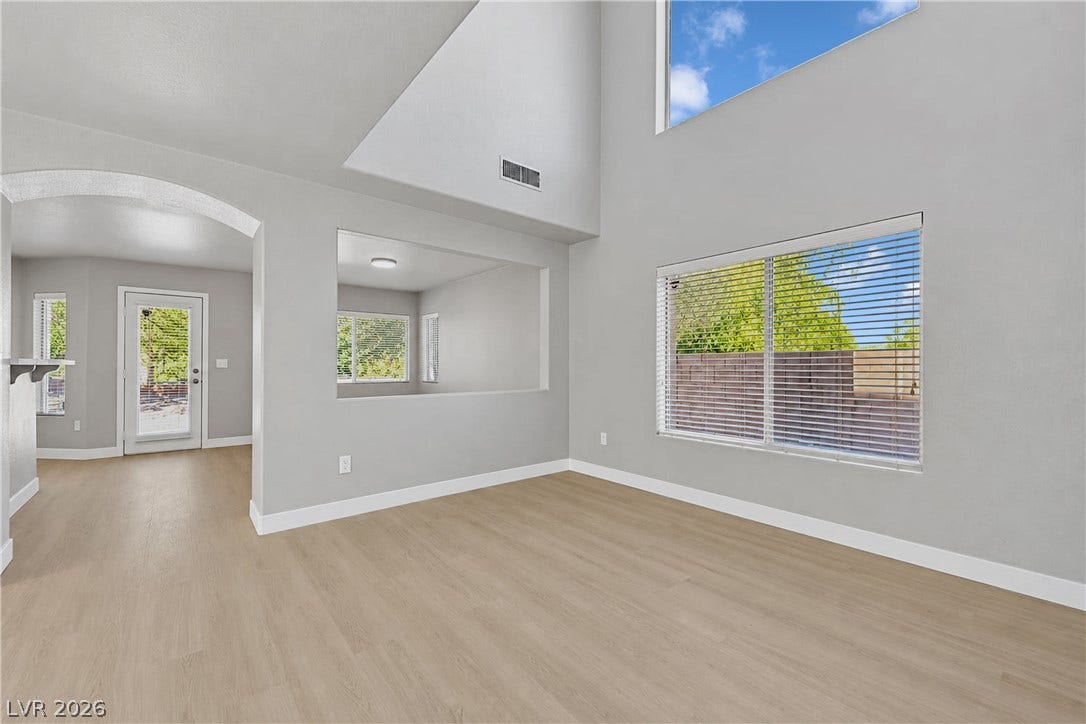 Towering ceilings and multi-level windows illuminate the seamless wood-look flooring throughout this open space.