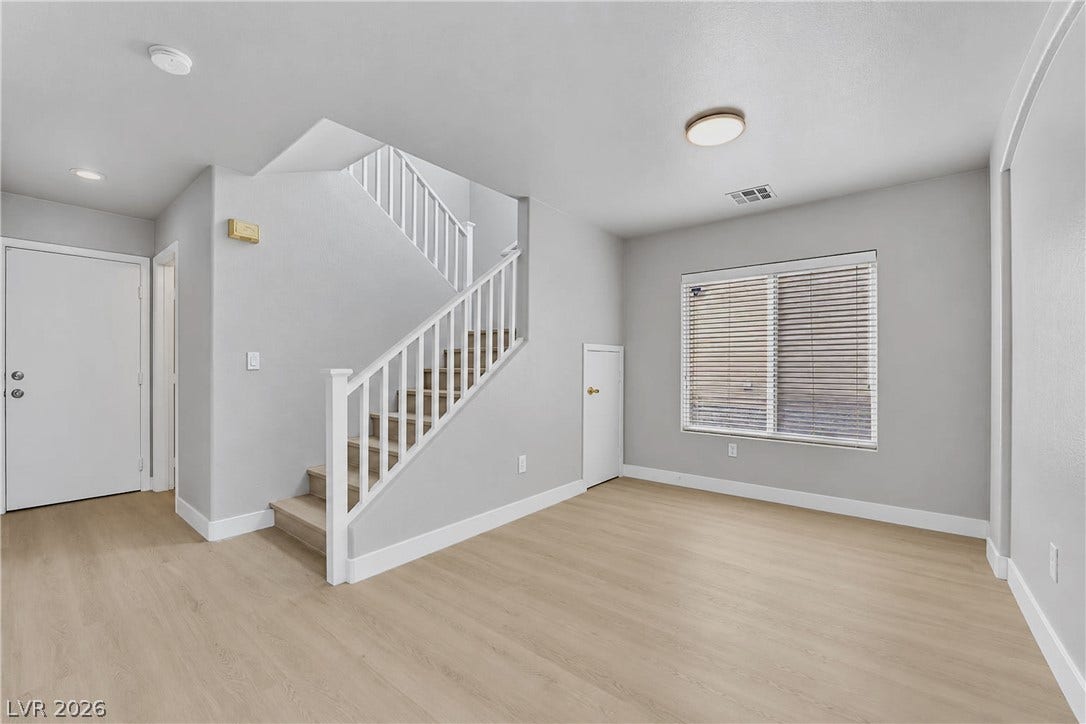Clean lines and light flooring anchor this versatile entryway featuring a classic staircase.