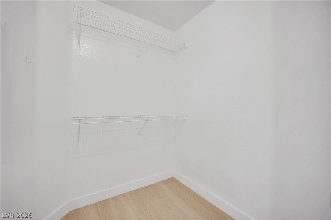 Ample wire shelving lines this functional storage space featuring clean wood flooring.