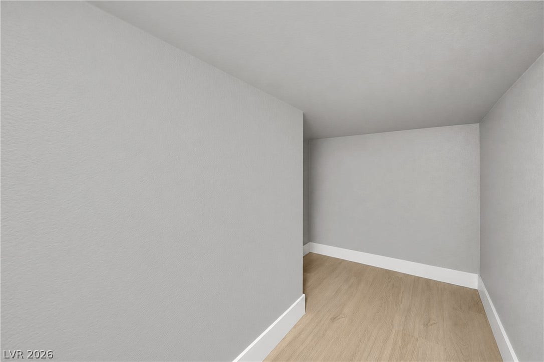 Crisp white baseboards contrast with smooth walls and clean wood flooring.