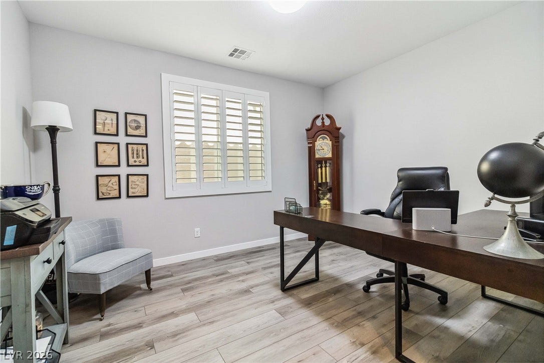 Smooth wood-plank flooring and a shuttered window anchor this quiet work space.