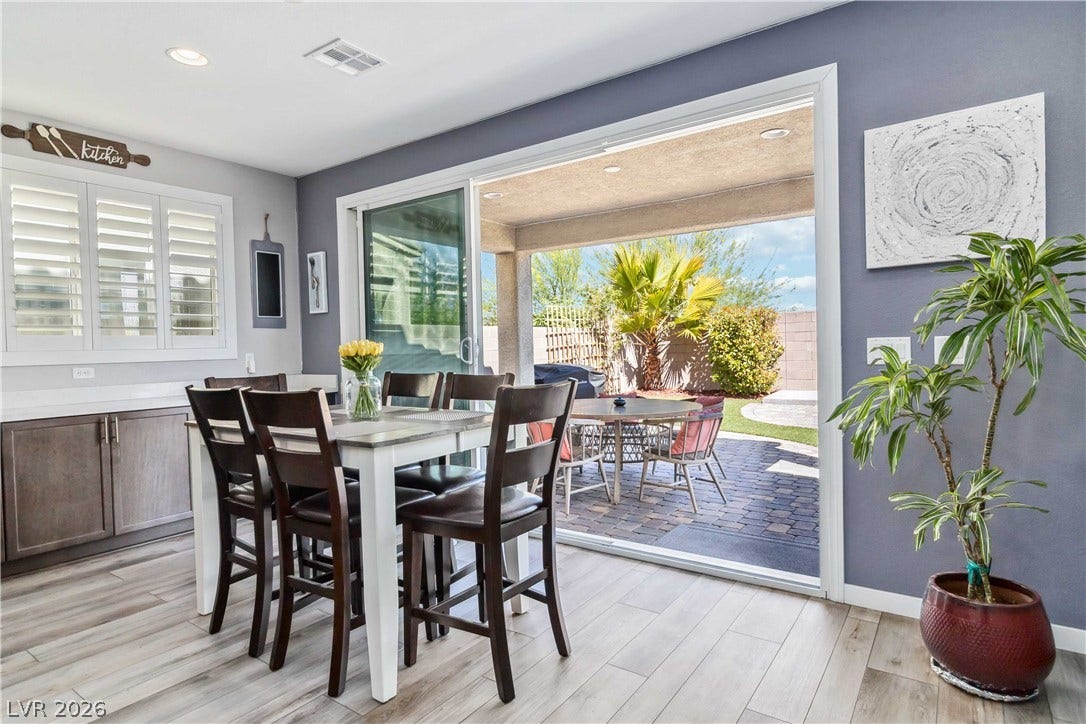 Wide sliding glass doors connect the casual dining space directly to the backyard patio.