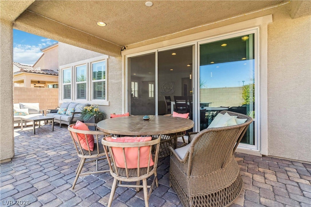 Shaded outdoor living spaces feature paved flooring under a covered structure.