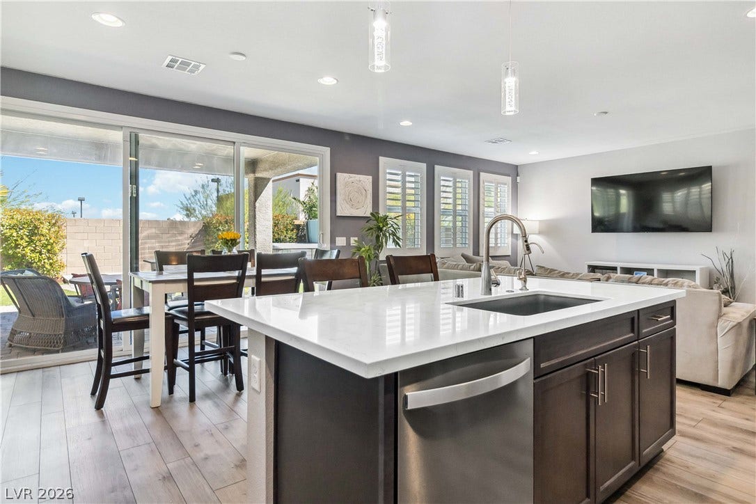 An open floor plan connects the kitchen island to the dining space and patio.