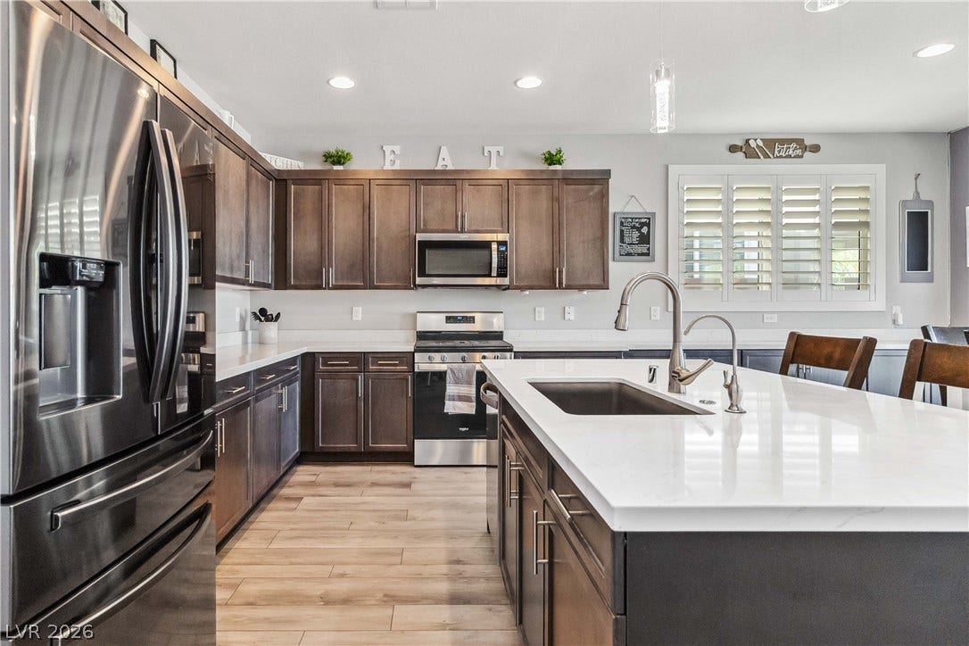 Rich dark wood cabinetry paired with gleaming white countertops defines this modern culinary workspace.