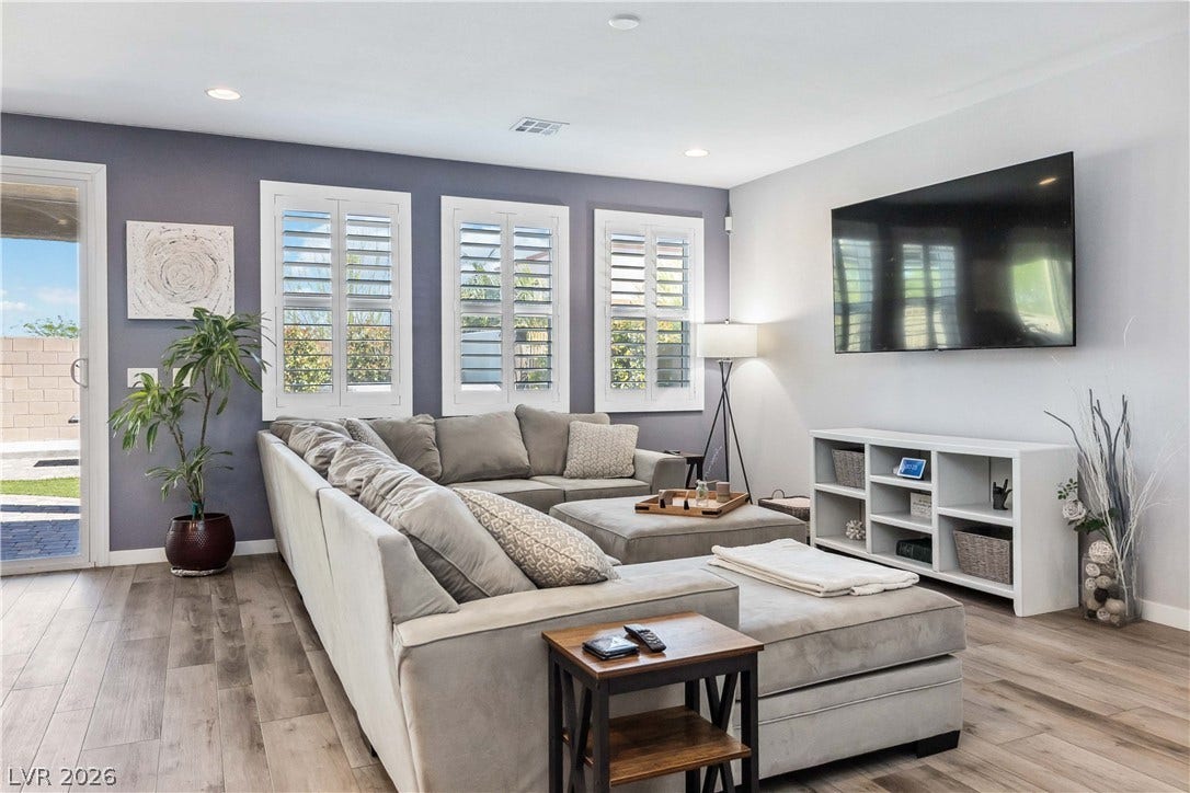 Recessed lighting and plantation shutters enhance this modern space featuring durable wood-look flooring.
