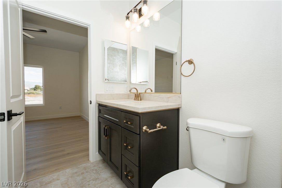 A modern vanity with brass hardware highlights this clean bathroom design.