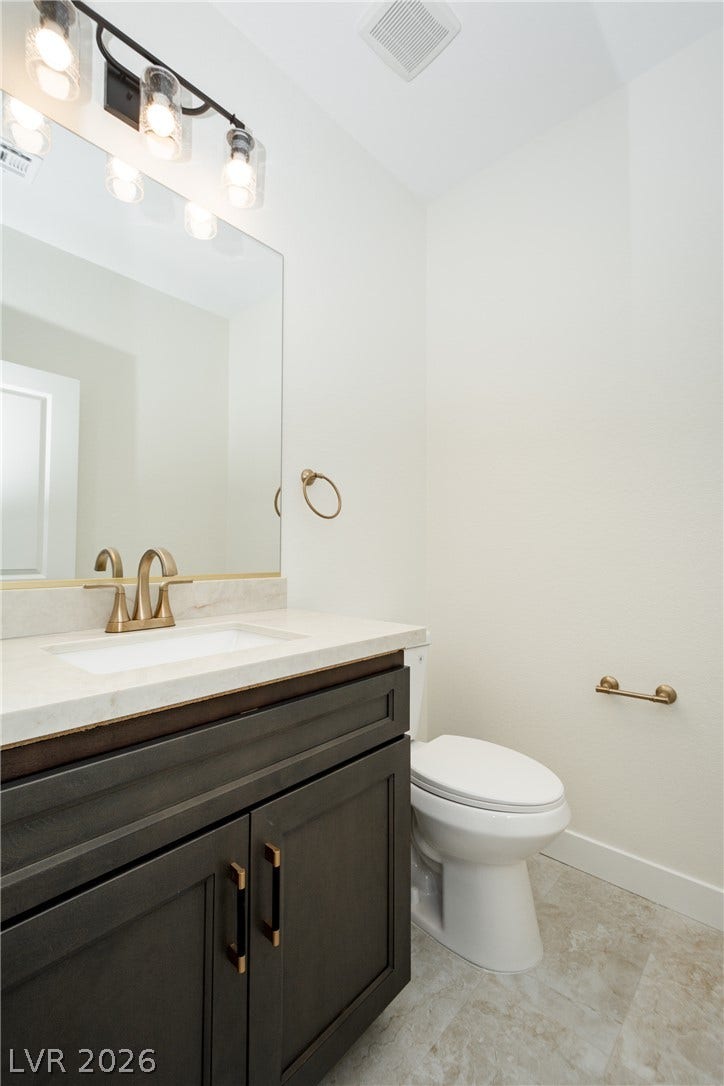 A classic stone vanity counter coordinates with elegant tiled flooring.