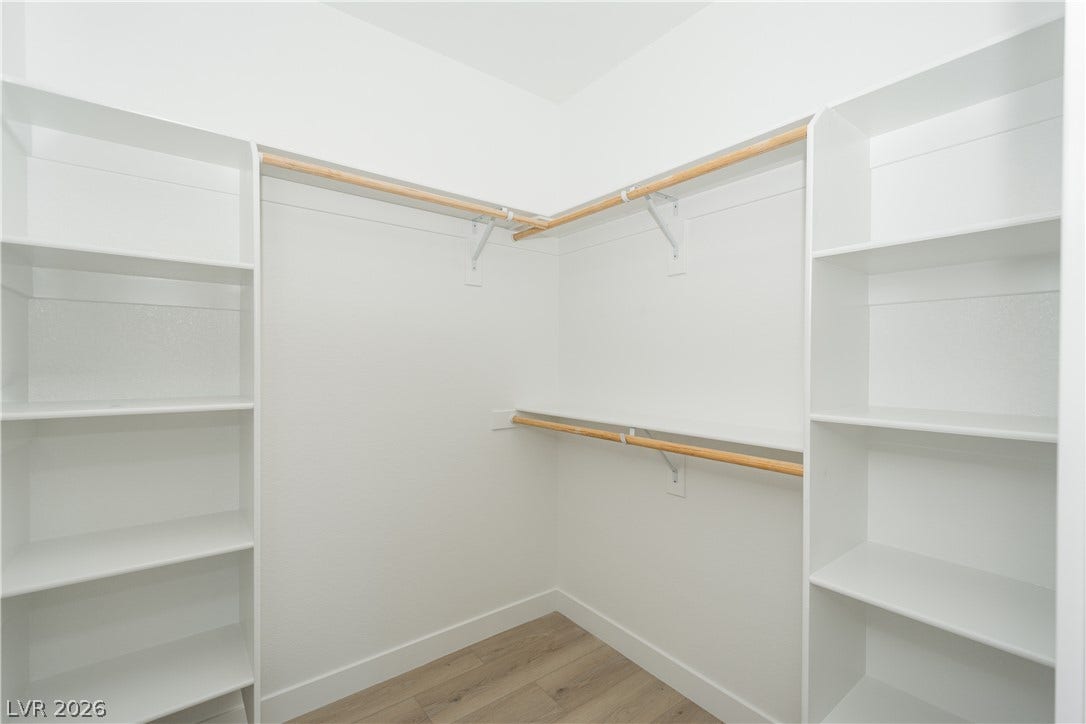 Generous storage solutions define this practical walk-in closet space with built-in shelving.