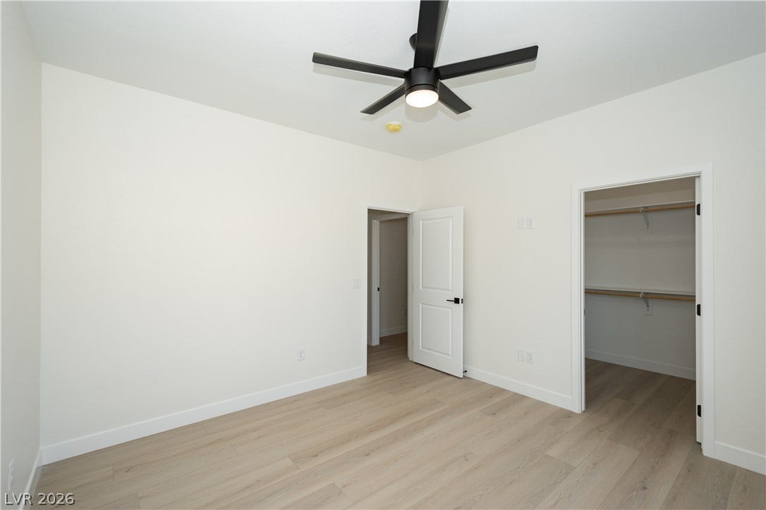 Gleaming light wood floors and clean white walls anchor this versatile modern bedroom.