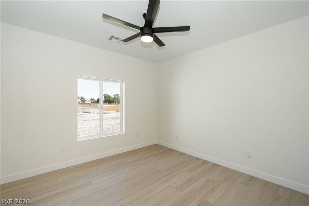 Smooth plaster walls and light-toned wood flooring frame a quiet bedroom filled with natural light.