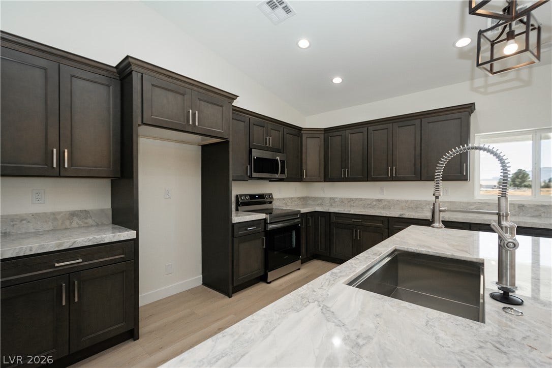 Rich dark cabinetry pairs beautifully with expansive stone countertops in this modern workspace.