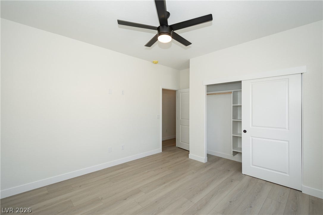 Smooth wood-style flooring and a built-in closet system define this versatile bedroom.