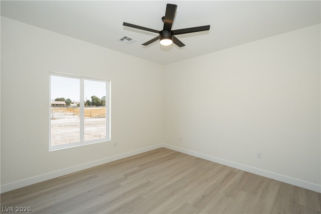 Smooth wood-style flooring and natural light define this versatile bedroom space.