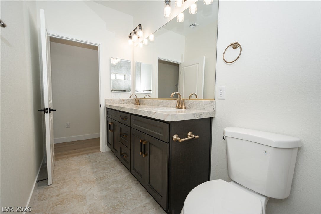 A spacious vanity with elegant stone countertops anchors this modern bathroom.