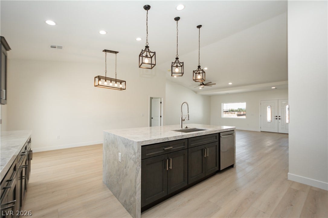 An open floor plan seamlessly connects the kitchen island to the bright living areas.