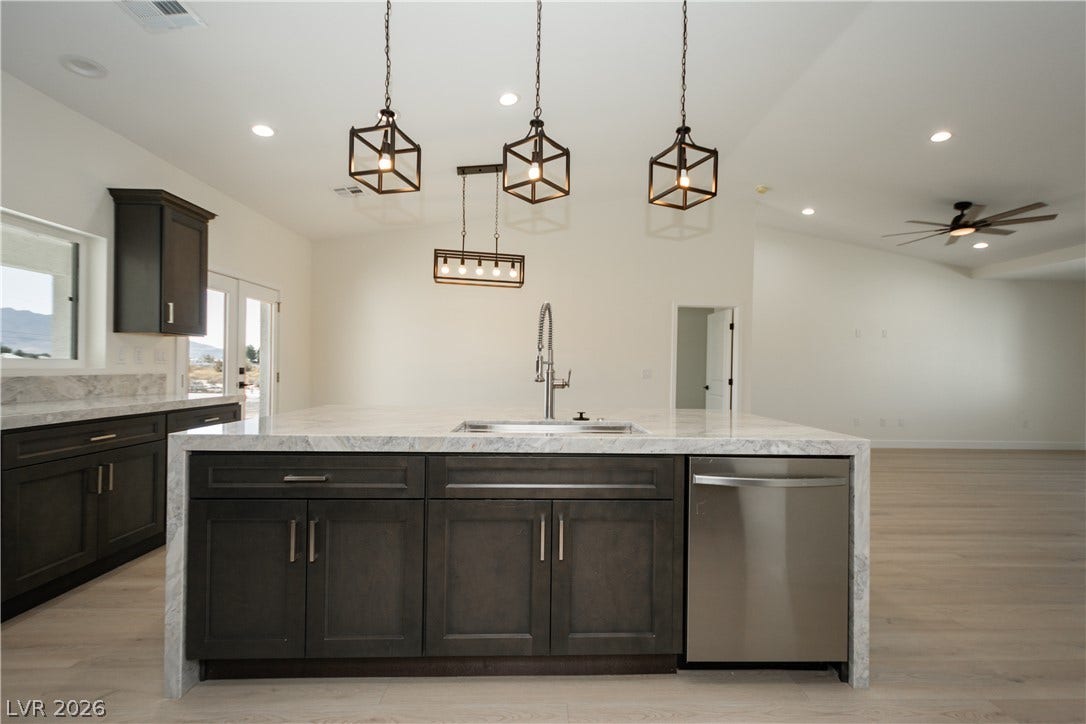 An expansive kitchen island anchors the open floorplan flowing into the living area.