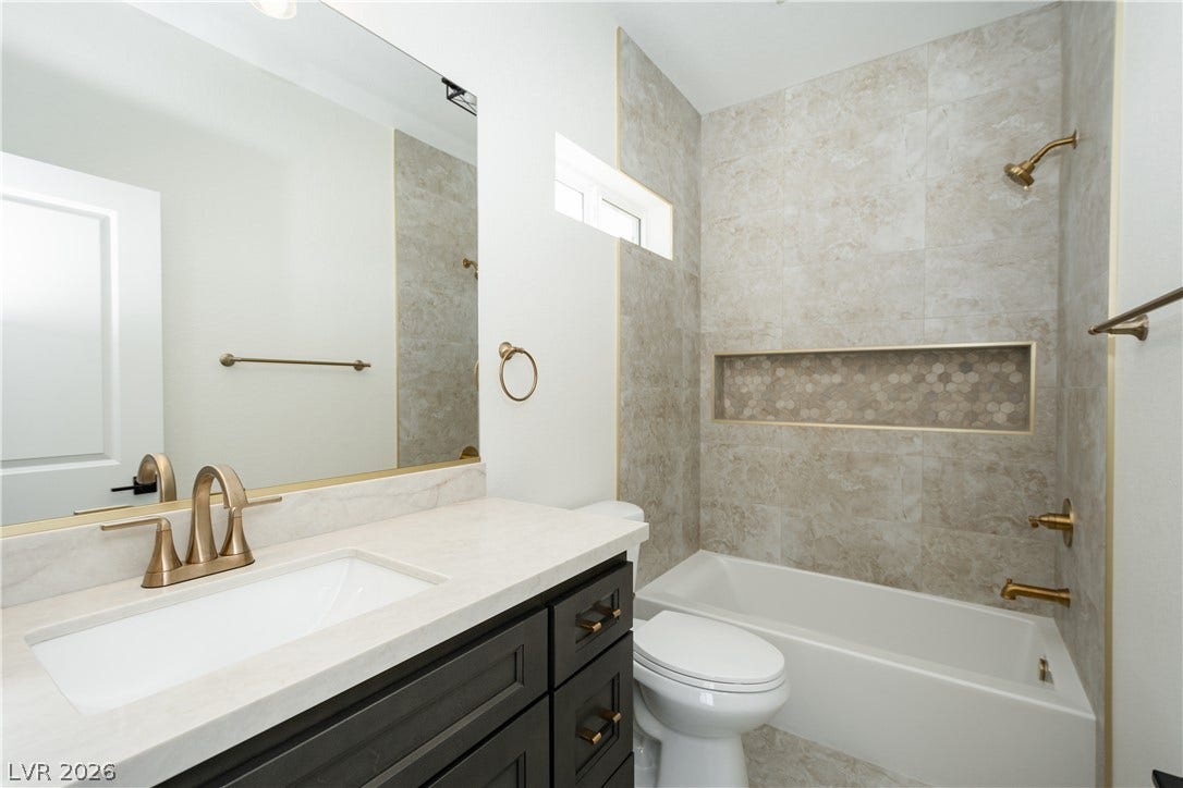 Modern stone counters and custom shower tile define this elegant bathroom.