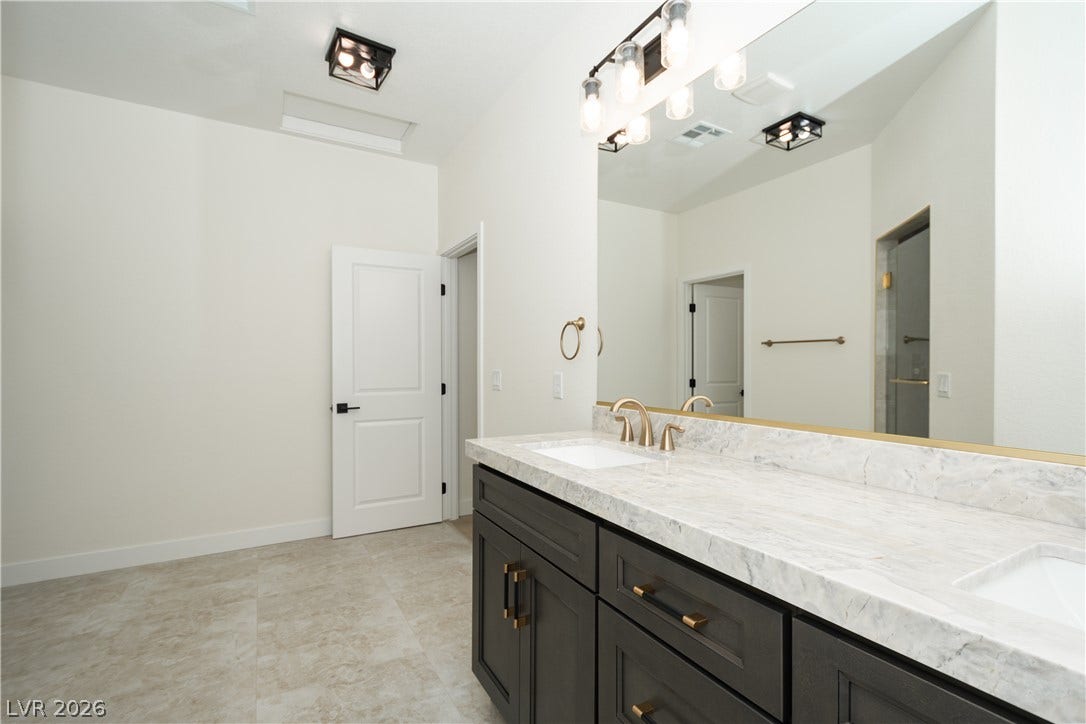 A spacious double vanity with marble countertops anchors this contemporary bathroom.