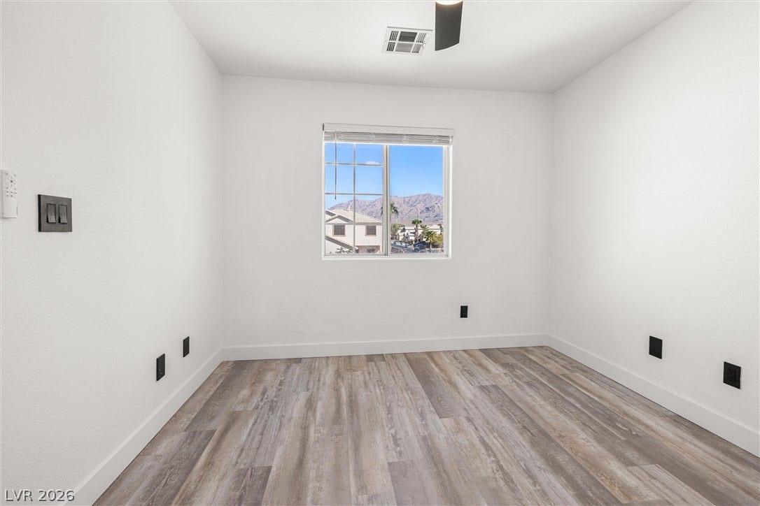 4817 Whispering Spring Avenue, Las Vegas, NV 89131 Smooth wood-look flooring and crisp walls frame picturesque mountain views through a central window.