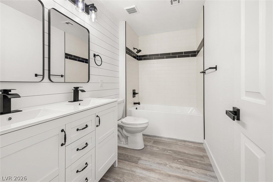 4817 Whispering Spring Avenue, Las Vegas, NV 89131 A modern double vanity pairs with clean tilework and classic wood-look flooring.
