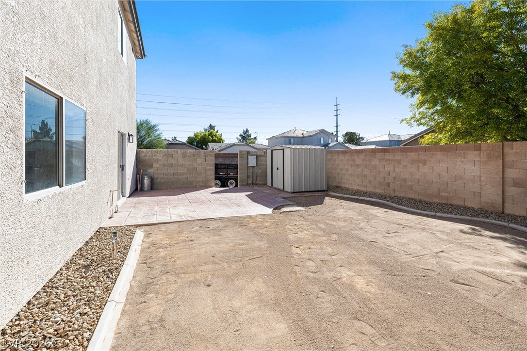 4817 Whispering Spring Avenue, Las Vegas, NV 89131 A spacious, walled backyard offers a paved patio area and a detached storage shed.