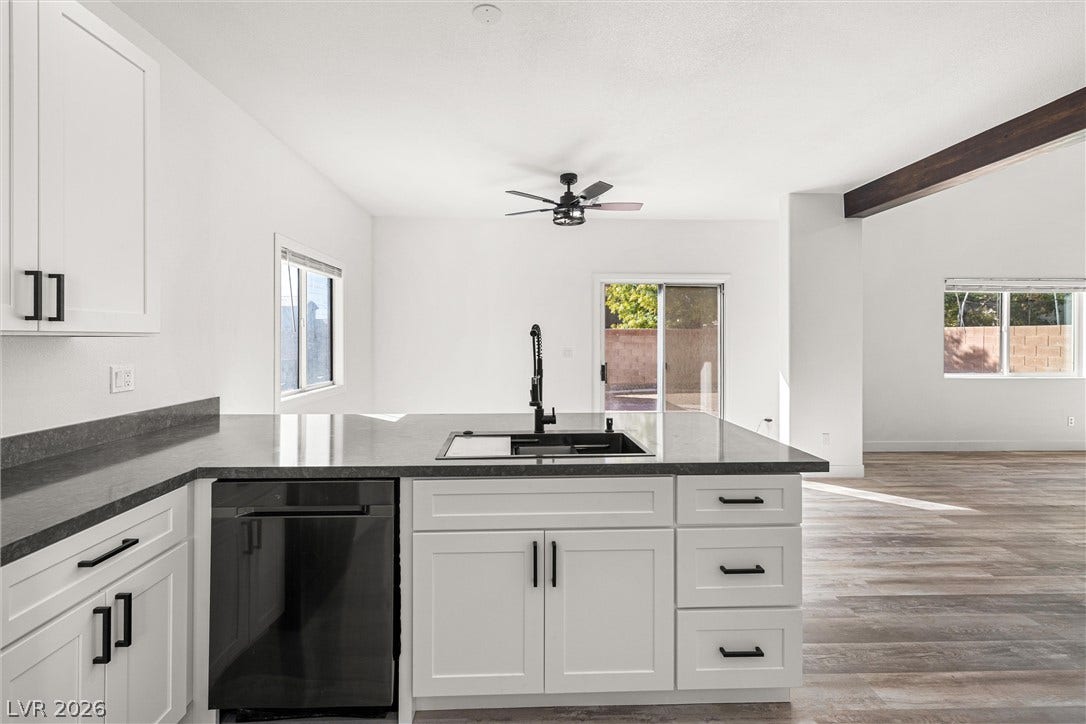 4817 Whispering Spring Avenue, Las Vegas, NV 89131 Gleaming stone countertops and modern cabinetry highlight this open-concept kitchen space.