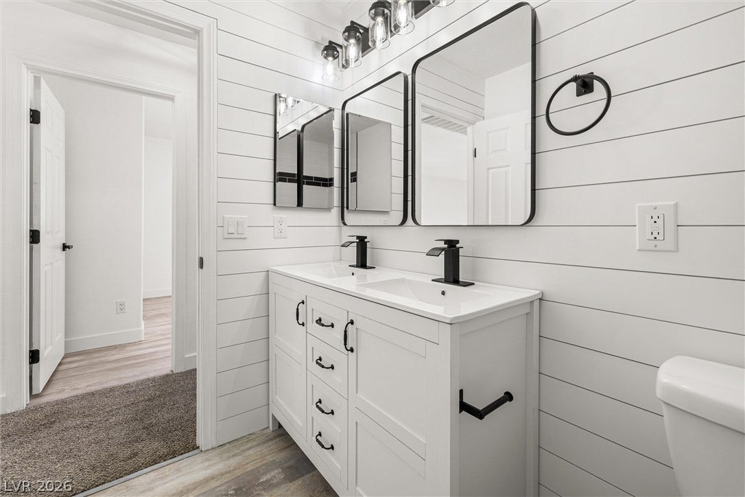 4817 Whispering Spring Avenue, Las Vegas, NV 89131 Shiplap paneling and modern black fixtures elevate this refreshed double-vanity bathroom.