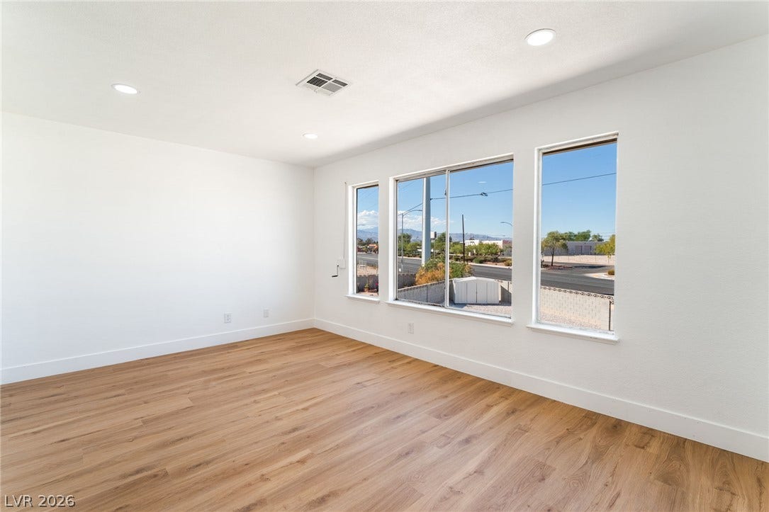 Warm wood floors and recessed lighting complement the natural light from large windows.