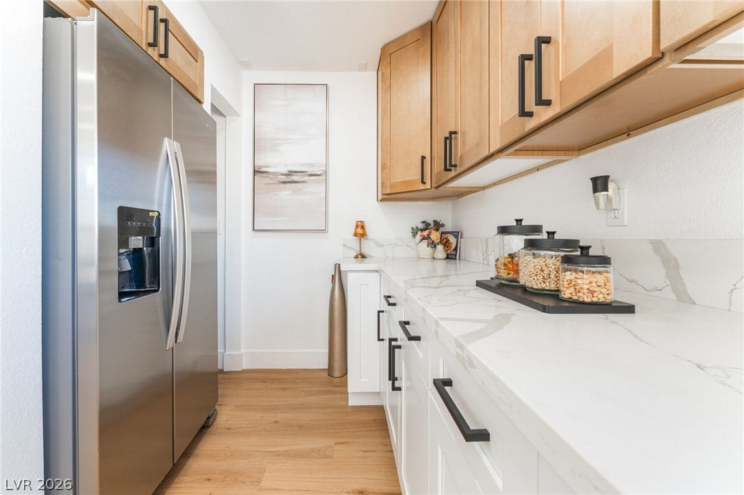 Gleaming stone countertops and warm wood cabinets define this modern culinary workspace.