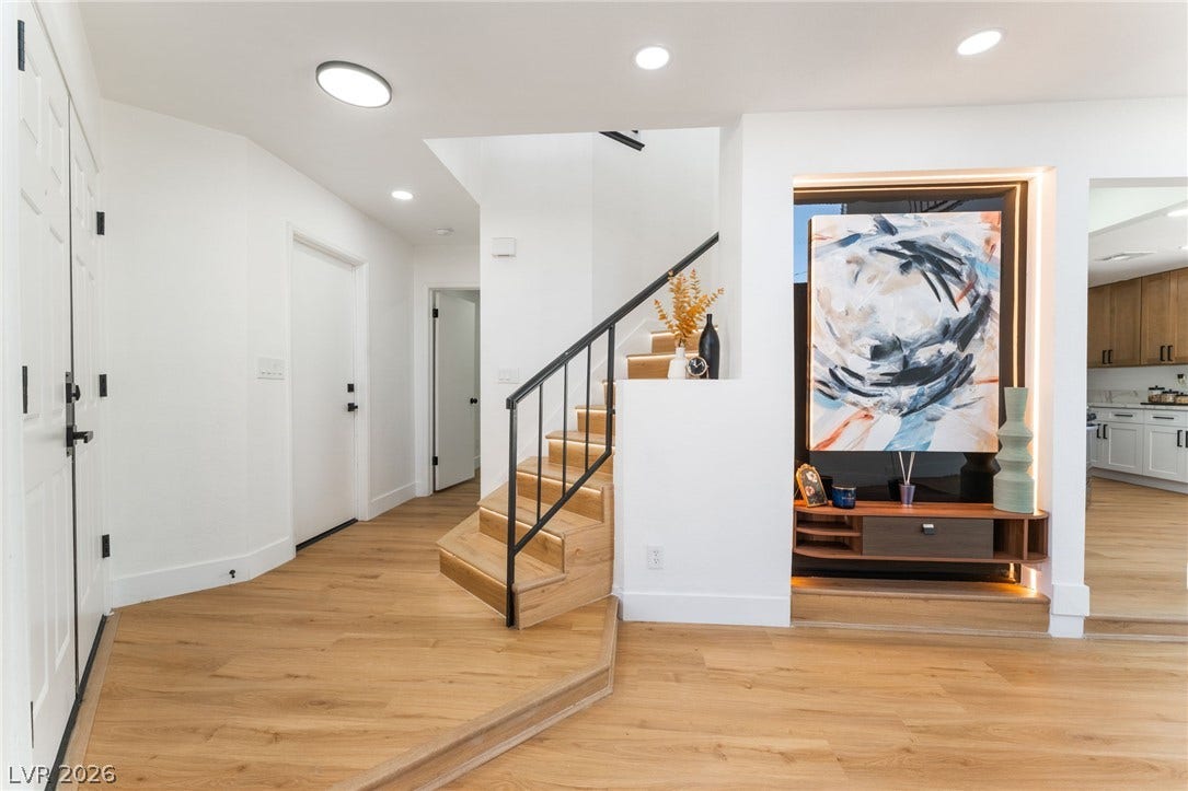Gleaming wood floors and a custom staircase highlight this welcoming entryway.
