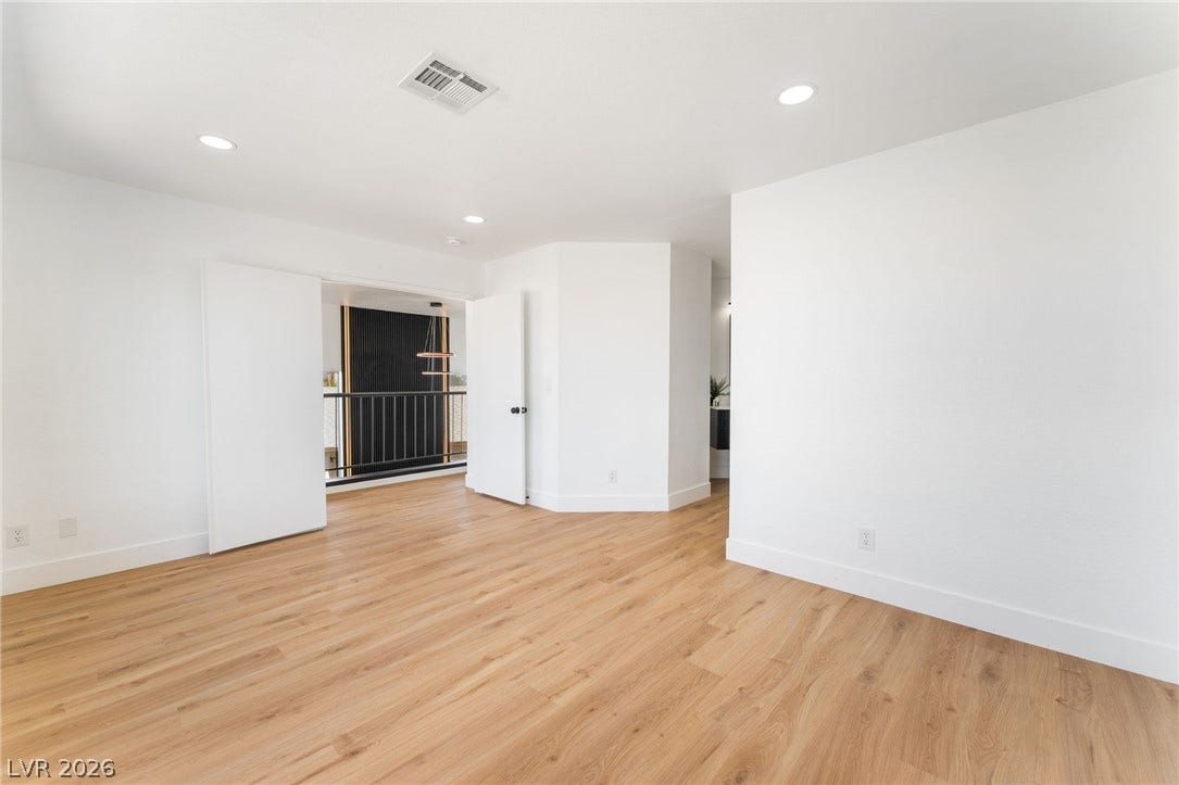 Warm wood flooring and clean white walls define this airy, versatile upper-level space.