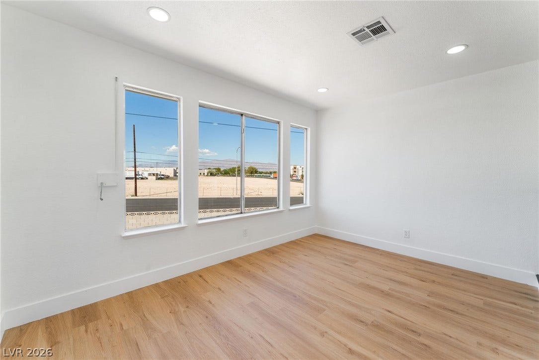 Warm wood flooring and clean white walls create a minimalist backdrop filled with natural light.