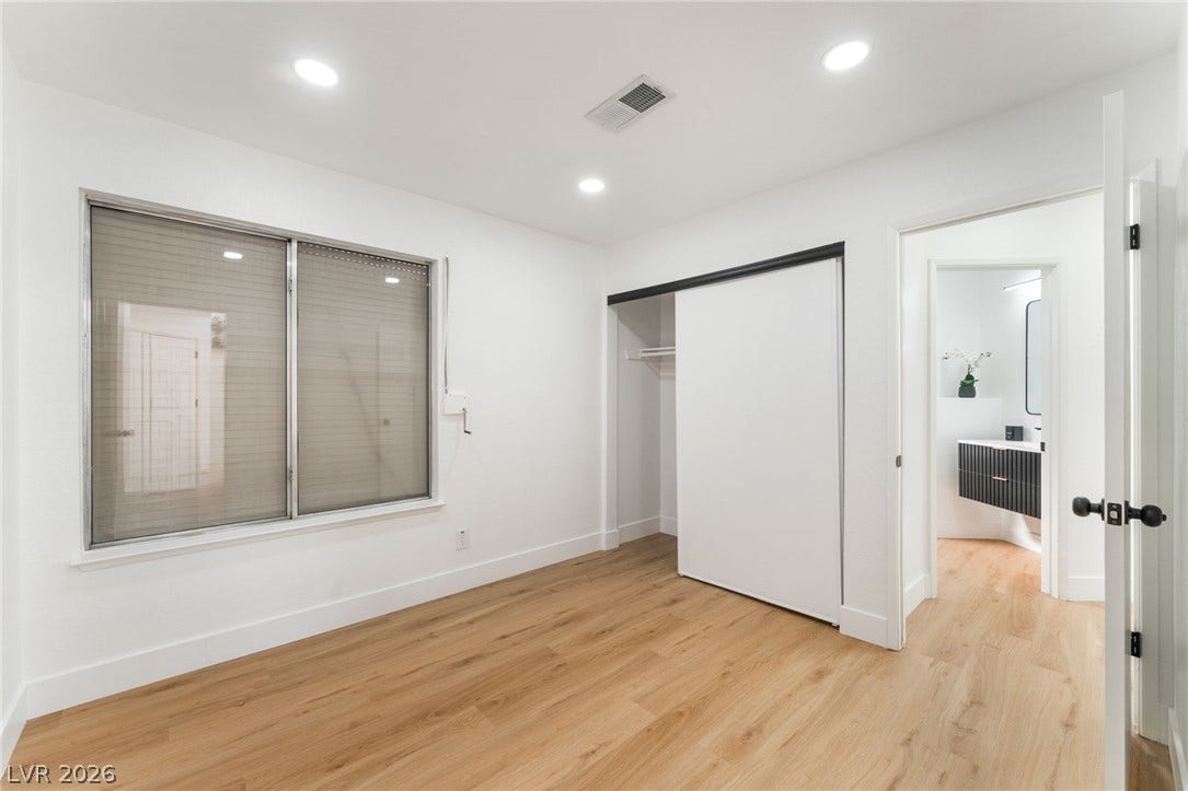 Recessed lighting and wide-plank wood flooring define this versatile secondary bedroom.