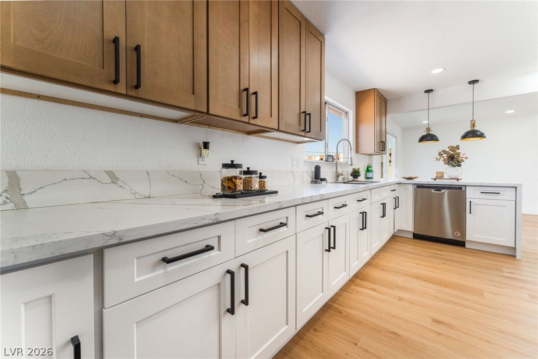 Gleaming stone countertops and warm wood floors define this beautifully updated cooking space.