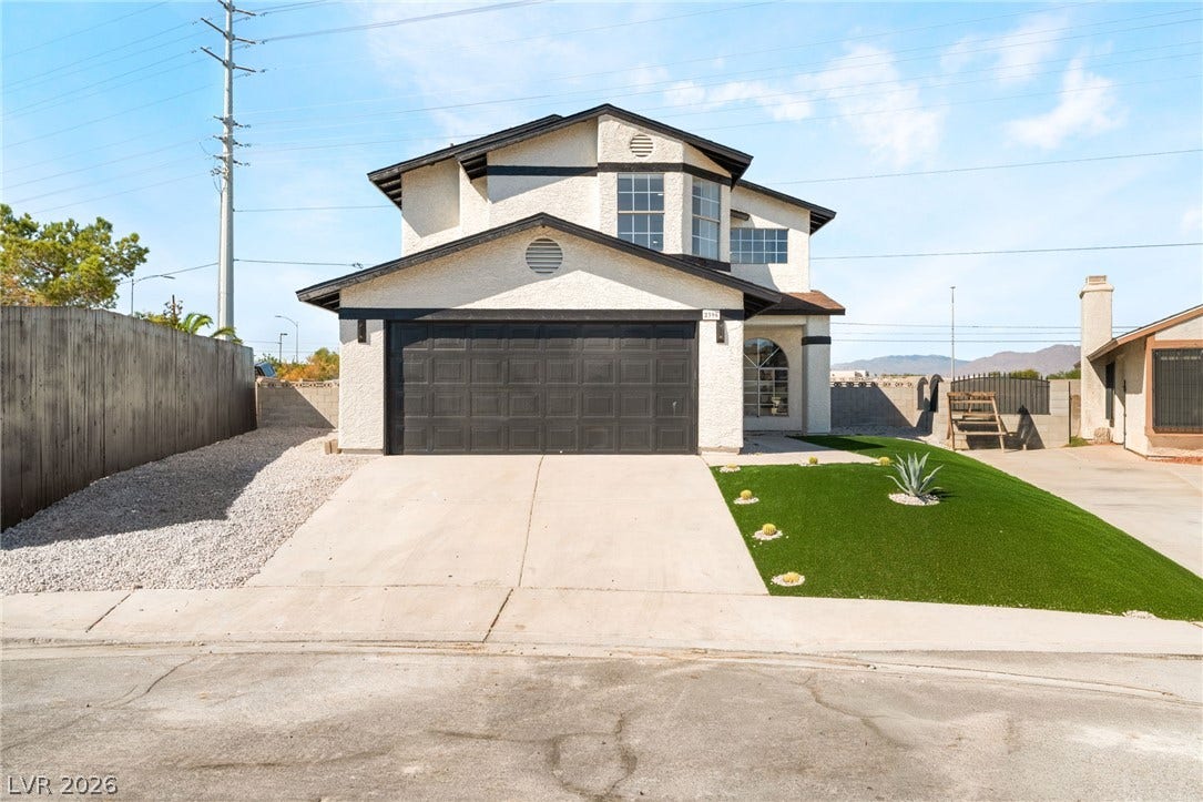 Crisp stucco and a wide concrete driveway define this modern two-story exterior facade.