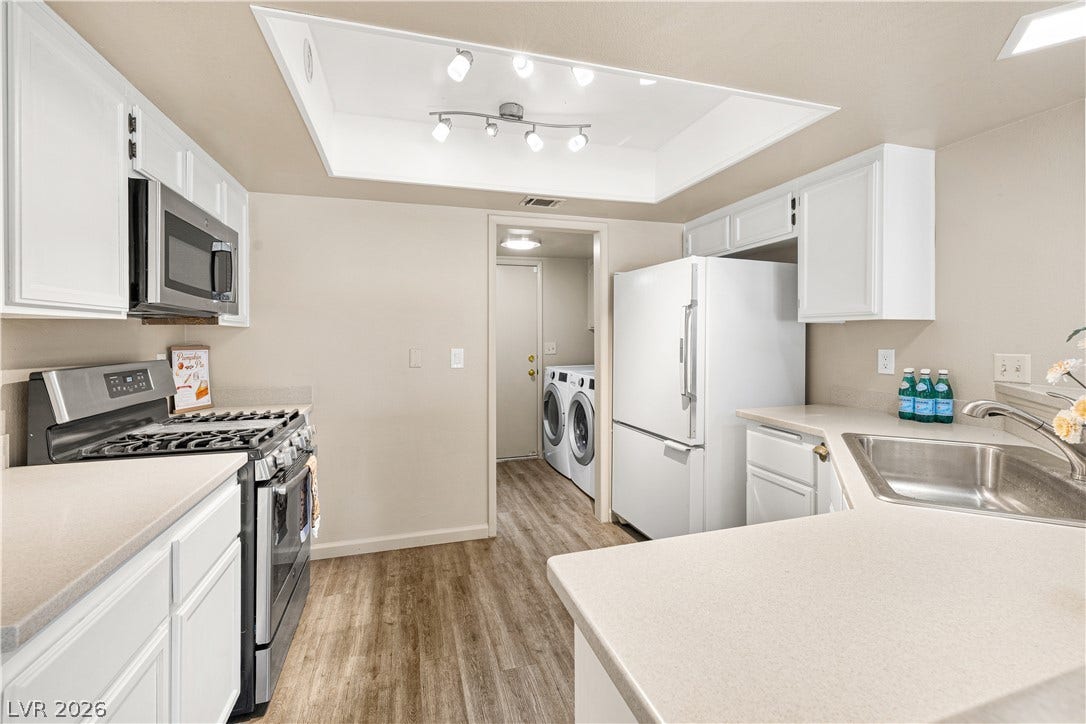 325 Manor Street, Las Vegas, NV 89145 White cabinetry and durable solid-surface countertops define this functional kitchen space.